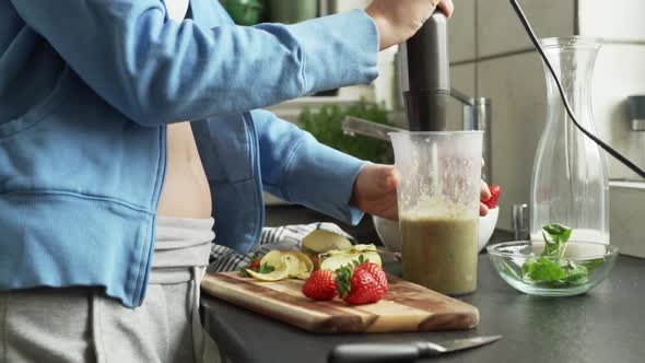 Woman preparing a fruit shake in the kitchen