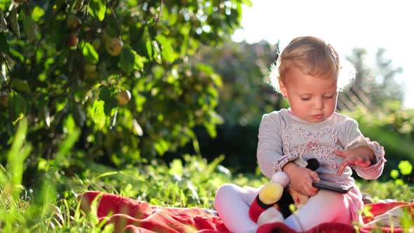 Happy Little Girl Sitting on the Green Grass