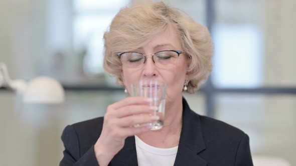 Portrait of Old Businesswoman Drinking Water