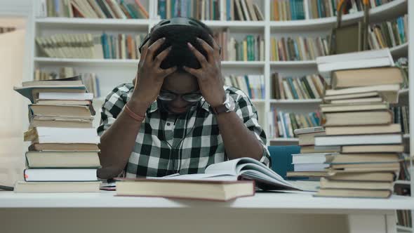 Stressful African Young Man Studying in Headphone