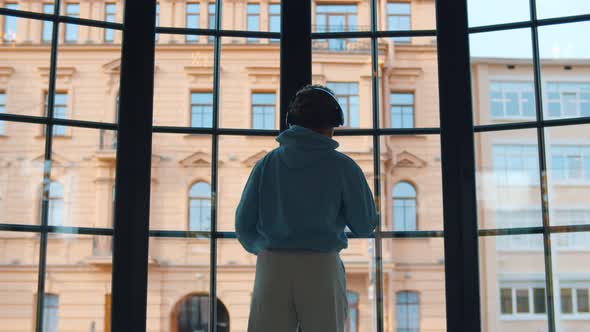 Back View of Happy African Woman in Headphones Dancing in Front of Panoramic Window