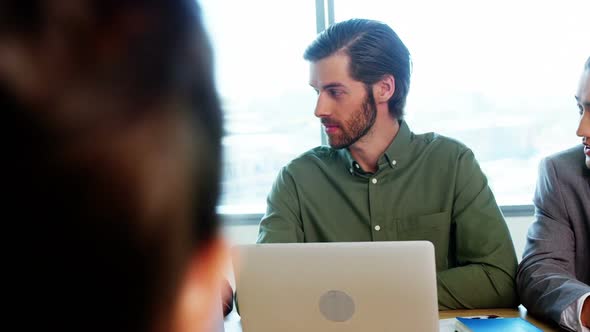 Smiling business team interacting with each other in conference room