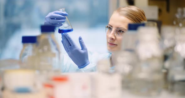 Scientist Mixing Flask at Laboratory in Molecular Biotechnology Laboratory