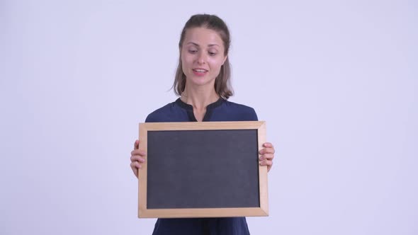 Happy Young Beautiful Businesswoman Talking While Holding Blackboard
