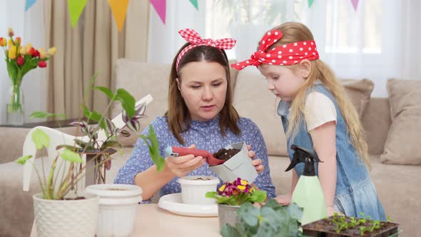 a Mother and Daughter Pour the Ground Into a Pot for Transplanting Houseplants