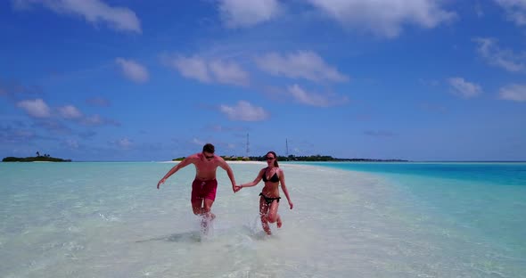 Young people married on vacation enjoy life on beach on summer white sandy background