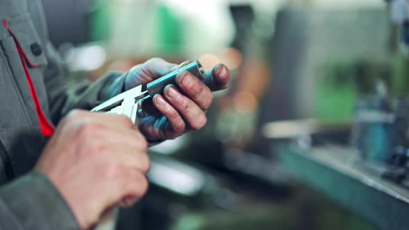 Worker is Measuring a Produced Detail by Caliper