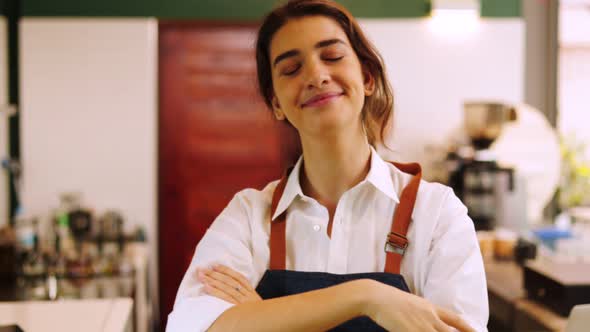 Portrait young Asian woman barista feeling happy smiling at urban cafe