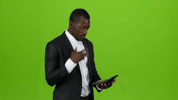 Businessman Calculates His Income on the Calculator, He Is Bankrupt. Green Screen