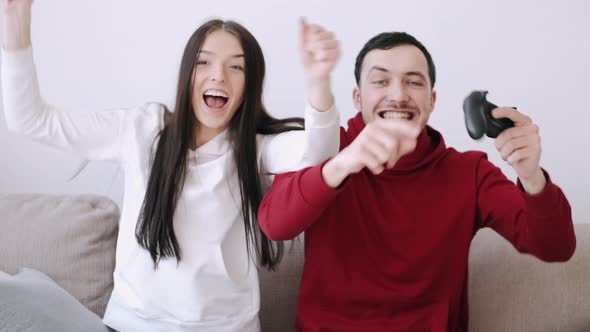 A Pretty Girl and a Boy Are Playing Video Games in the Living Room