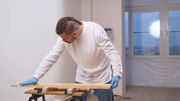 the Carpenter Covers the Wood with Oil with a Napkin