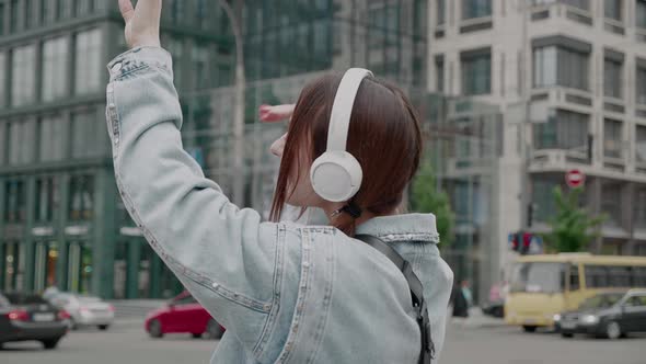 Happy Woman Dancing on Headphones Outside