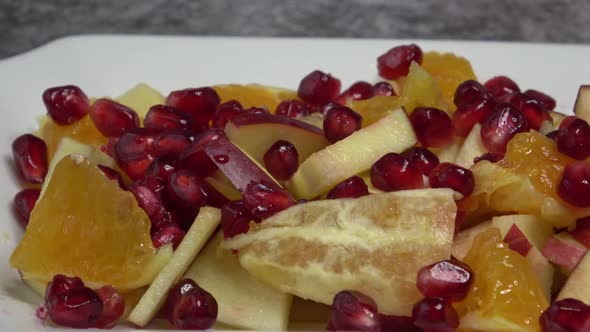 Delicious fruit salad with fresh fruit. Pomegranate, orange, apple