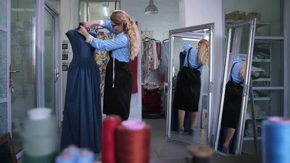 Tailor Doing Neckline Cutout of Dress on Mannequin