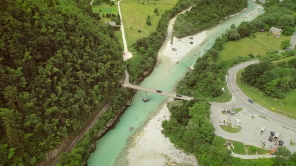 Aerial view of a group of people doing rafting going under a bridge.