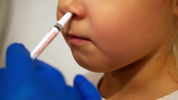 Clouse up Shot of Child Getting a Nasal Vaccine .