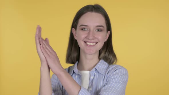Clapping Young Woman Applauding on Yellow Background