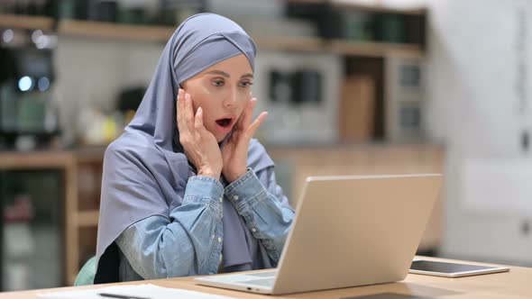 Arab Woman Reacting To Loss on Laptop at Work 