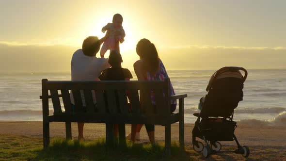 Happy Family Playing and Having Fun on the Beach at Sunset