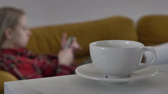 woman lying on the sofa using her phone, surfing the internet