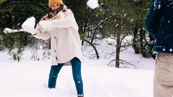 Happy Couple Playing Snowball Fight Game in Winter