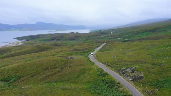 Aerial Drone View of Scotland Highlands Road Trip Driving Holiday in Mountains, with Car on Scottish