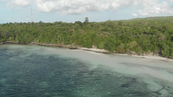 Aerial: Flying over tropical beach turquoise water coral reef , Tomia island Wak