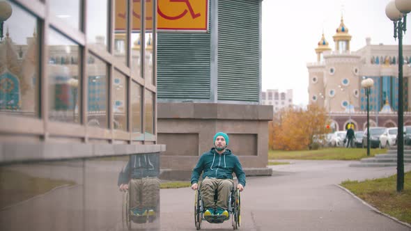Disabled Man in Wheelchair Sees the "Disabled" Sign and Moving Towards the Special Place
