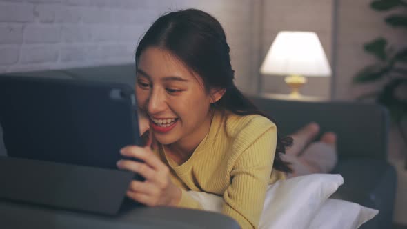 Young Woman Using Digital Tablet Watching an Entertainment Movie Series at Home