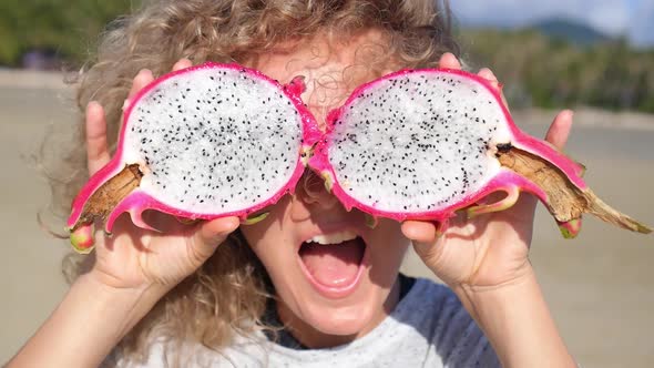 Girl Holding Dragon Fruit On Eyes Having Fun on Beach