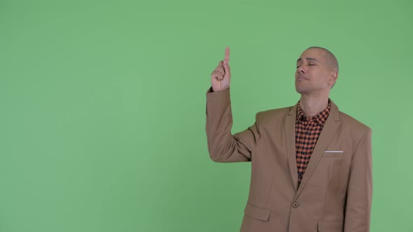 Sad Bald Multi Ethnic Businessman Pointing Up