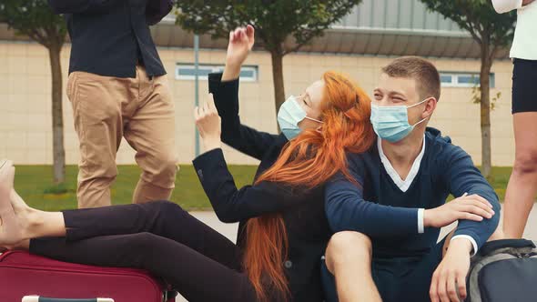 A Tourist Group in Medical Masks Who Are Having Fun Waiting for Their Flight. Young Happy Girl in a