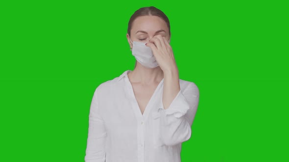 Woman Takes Off Medical Mask and Smiles Standing Against the Background of the Chromakey