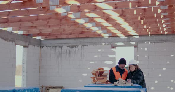 Concentrated Engineers Discussing Examining and Developing at Construction Site