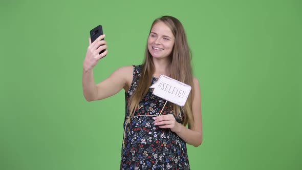 Young Happy Pregnant Woman Taking Selfie with Paper Sign