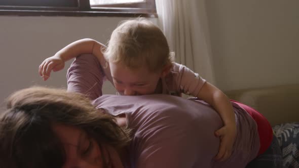 Caucasian woman with her baby at home in bedroom