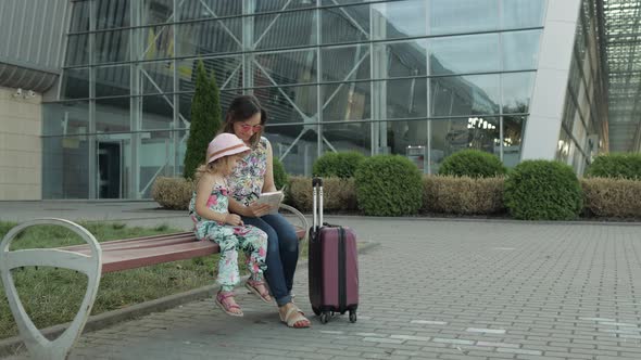 Mother and Daughter Near Airport. Woman Hold Passports and Tickets in Hand. Child and Mom Vacation