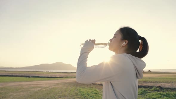 Athlete woman runner drinking water after running fitness workout.