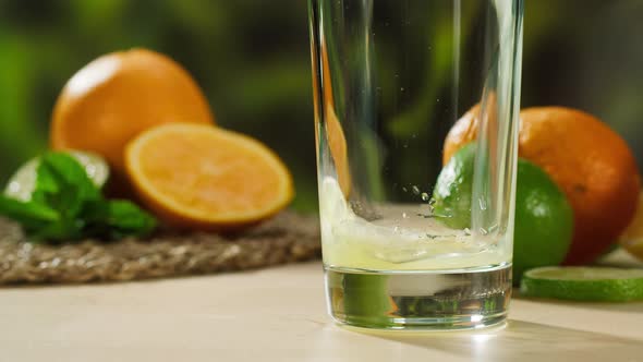 Pouring Orange Juice on Green Nature Background