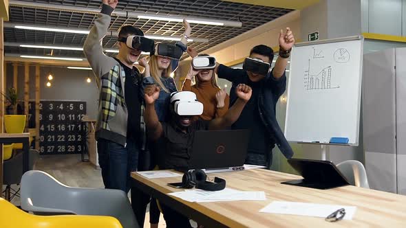 Young Business Team in VR Virtual Reality Glasses Looking to the Laptop