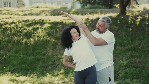 Middle Aged Man and Woman Doing Morning Exercises