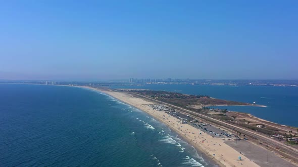 Side panning shot of Coronado beach in San Diego California with clear blue sky and the beautiful pa