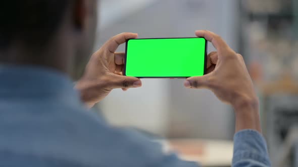 African Man Watching Video on Smartphone with Chroma Screen