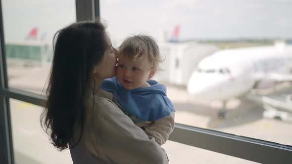 Closeup of Attractive Young Mother and Little Daughter Looking Out Window Airport Terminal with