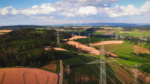 Transmission towers with power lines at countryside fields