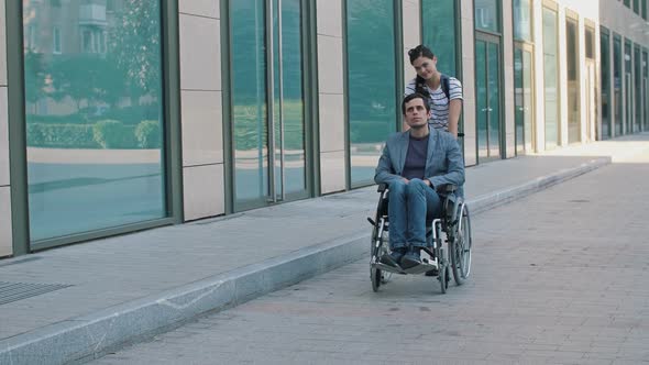 Young Man in Wheelchair and Woman at the City