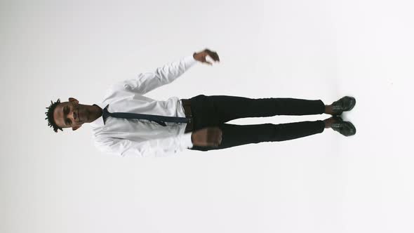 Black Man in Office Clothes Stands on White Background Happily Dancing with Smile Celebrating