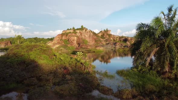 Aerial view move from shade toward abandoned quarry