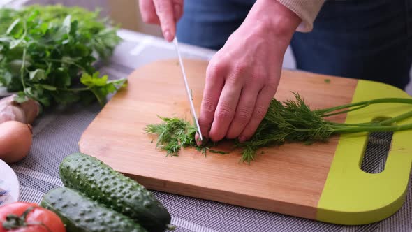 Closeup of Woman Slicing Dill on Wooden Cutting Board  Preparing Ingredient for Meal