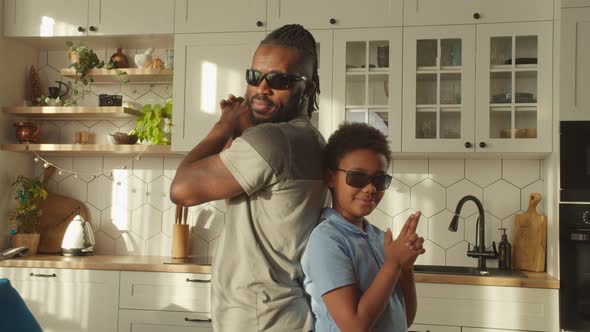 Cheerful African Father and School Age Boy Shooting with Finger Gun Gesture